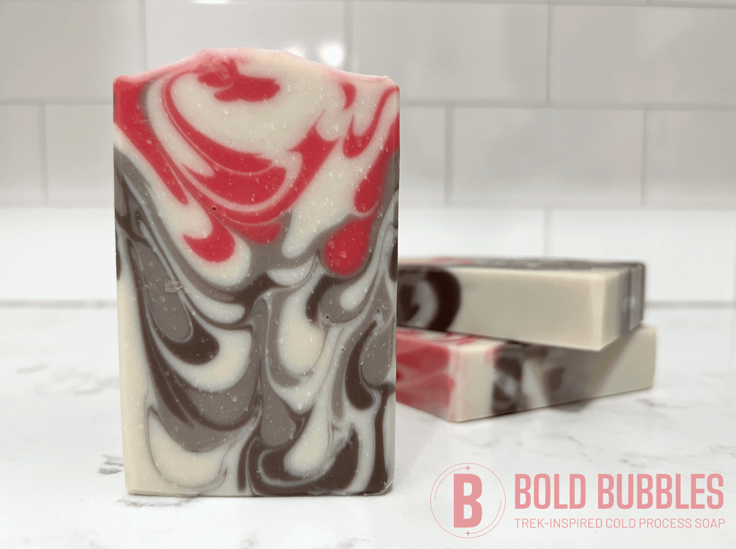 Bars of soap inspired by Jankom Pog from Star Trek: Prodigy. The hot pink, brown, and white bars were created with the drop swirl technique, and smell like rosemary mint.