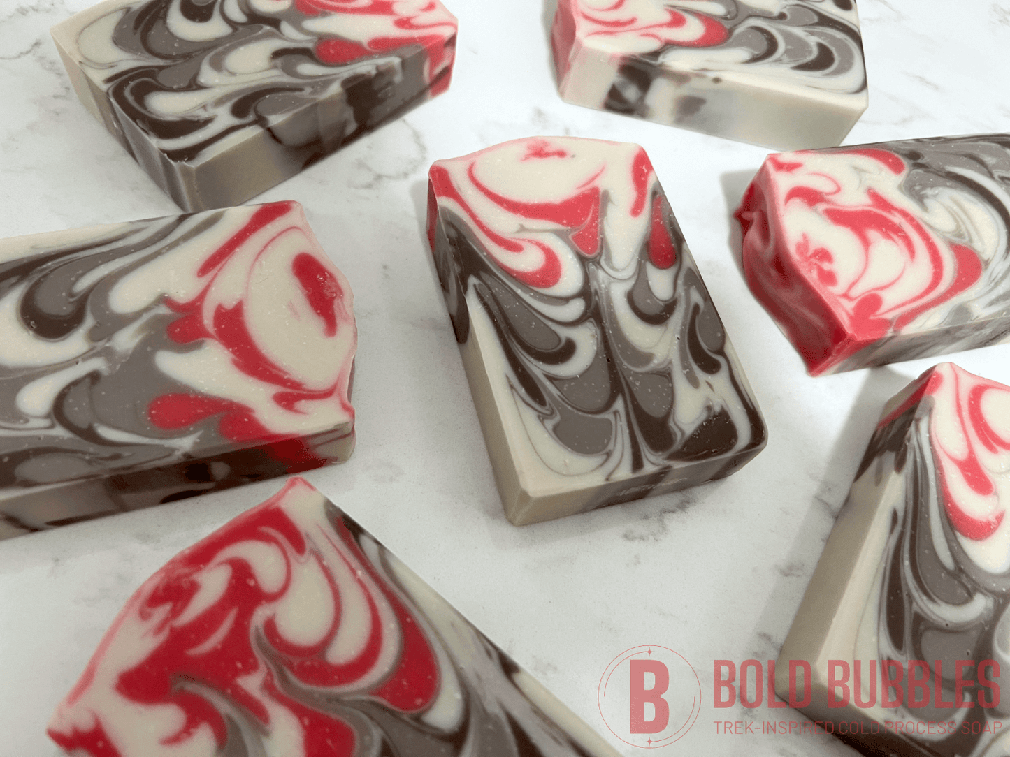 Bars of soap inspired by Jankom Pog from Star Trek: Prodigy. The hot pink, brown, and white bars were created with the drop swirl technique, and smell like rosemary mint.