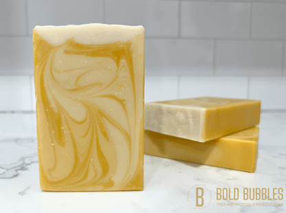 A bar of soap with swirls of varying shades of white and yellow, and a glittery white top. The scent and design was inspired by Bajoran ale, as seen on Star Trek: Deep Space Nine.