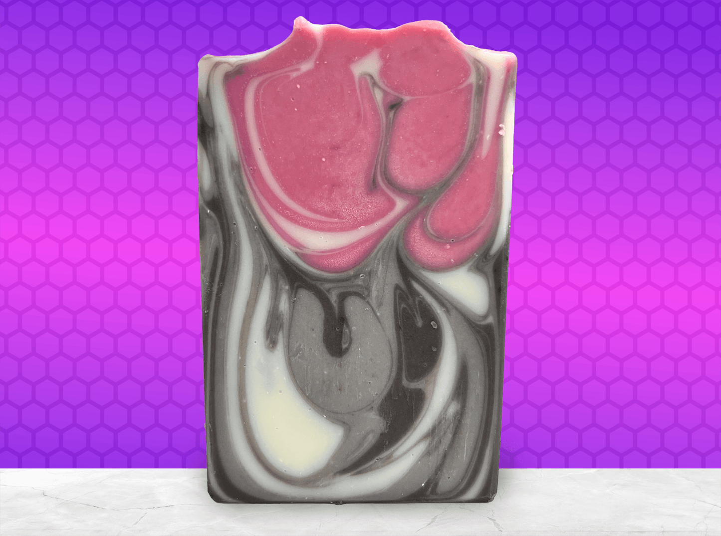 A bar of soap inspired by Jankom Pog from Star Trek: Prodigy. The hot pink, brown, and white bars were created with the drop swirl technique, and smell like rosemary mint.
