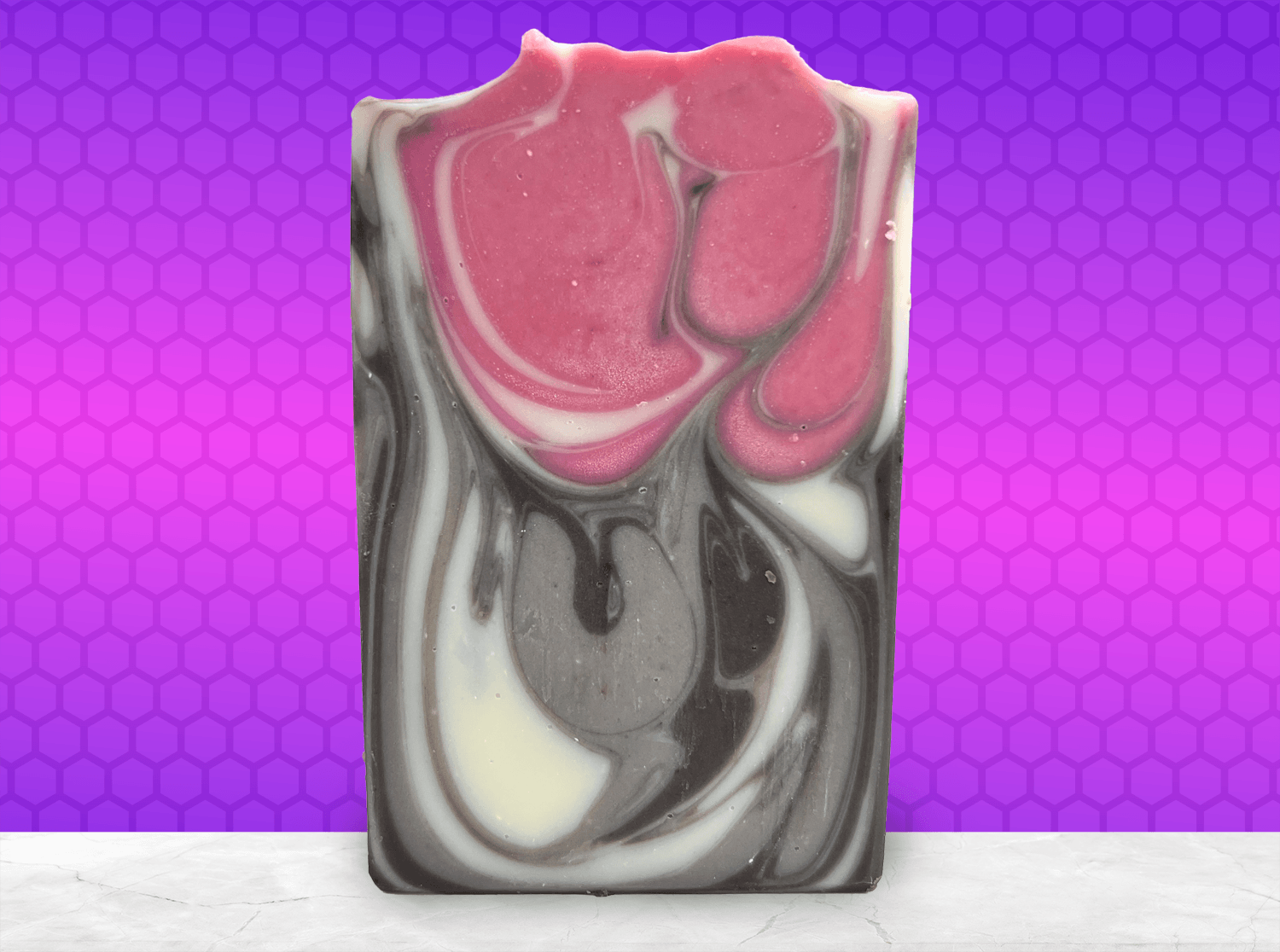 A bar of soap inspired by Jankom Pog from Star Trek: Prodigy. The hot pink, brown, and white bars were created with the drop swirl technique, and smell like rosemary mint.