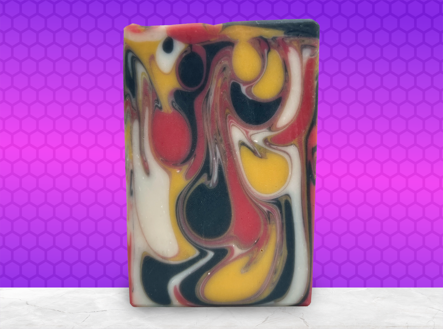 A bar of red, white, gold and black drop swirled soap, representing the colors of the Klingon Empire flag. The soap is scented with a blood orange fragrance.