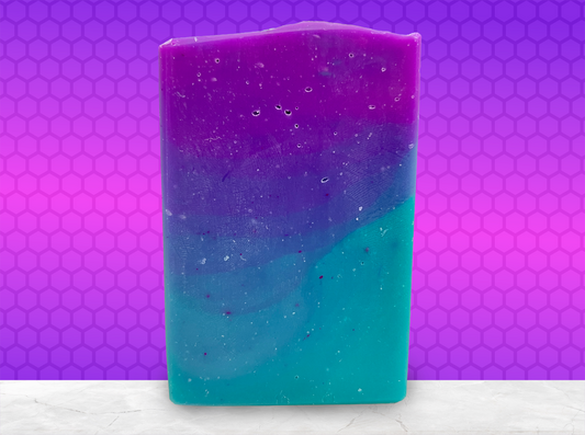 Gradient purple to blue soap bar on a purple and pink hexagonal background. The colors are inspired by Murf from Star Trek: Prodigy, and the scent is fresh mango.