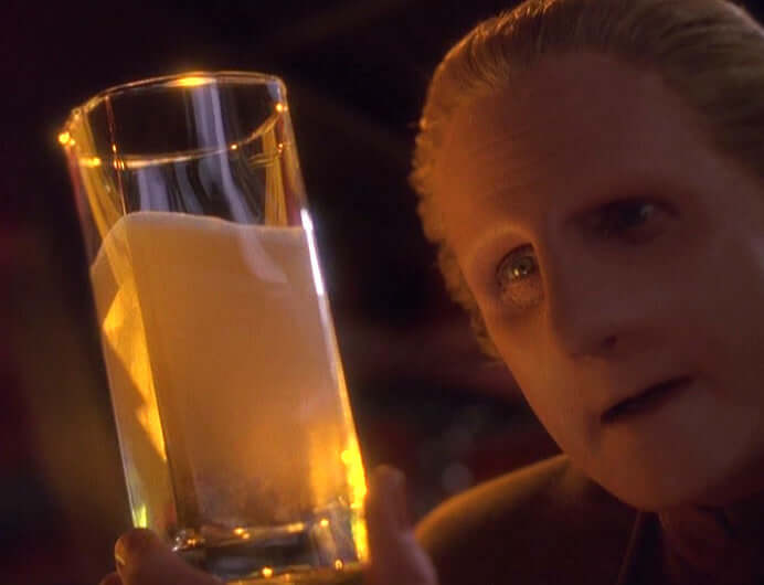 Odo takes a long look at the Bajoran ale he's drinking in the Star Trek: Deep Space Nine episode "Apocalypse Rising."