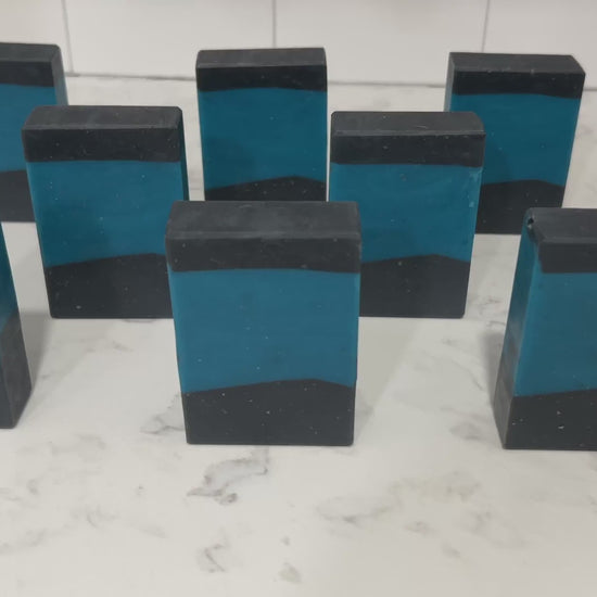 Bars of blue and black soap inspired by the iconic uniforms worn on Star Trek: The Next Generation. The scent is mint frosting, AKA spearmint, in honor of the time Troi became a cellular peptide cake with mint frosting.