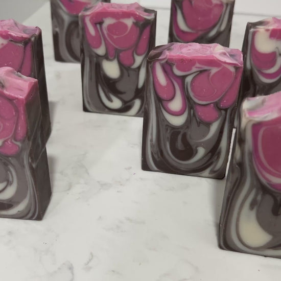 Bars of soap inspired by Jankom Pog from Star Trek: Prodigy. The hot pink, brown, and white bars were created with the drop swirl technique, and smell like rosemary mint.