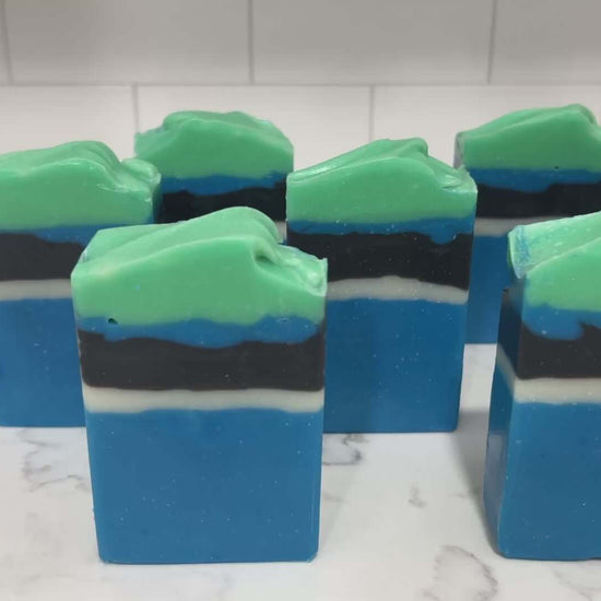 Bars of blue, white, and black soap designed in the Star Trek: Lower Decks-style uniform. At the top is a layer of green for D'Vana Tendi's hair. The scent is eucalyptus mint.