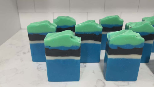 Bars of blue, white, and black soap designed in the Star Trek: Lower Decks-style uniform. At the top is a layer of green for D'Vana Tendi's hair. The scent is eucalyptus mint.