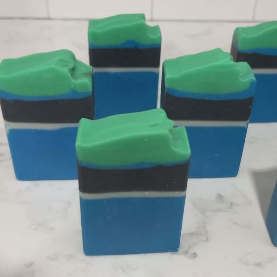 Bars of blue, white, and black soap designed in the Star Trek: Lower Decks-style uniform. At the top is a layer of green for D'Vana Tendi's hair. The scent is eucalyptus mint.