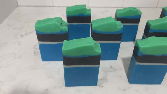 Bars of blue, white, and black soap designed in the Star Trek: Lower Decks-style uniform. At the top is a layer of green for D'Vana Tendi's hair. The scent is eucalyptus mint.
