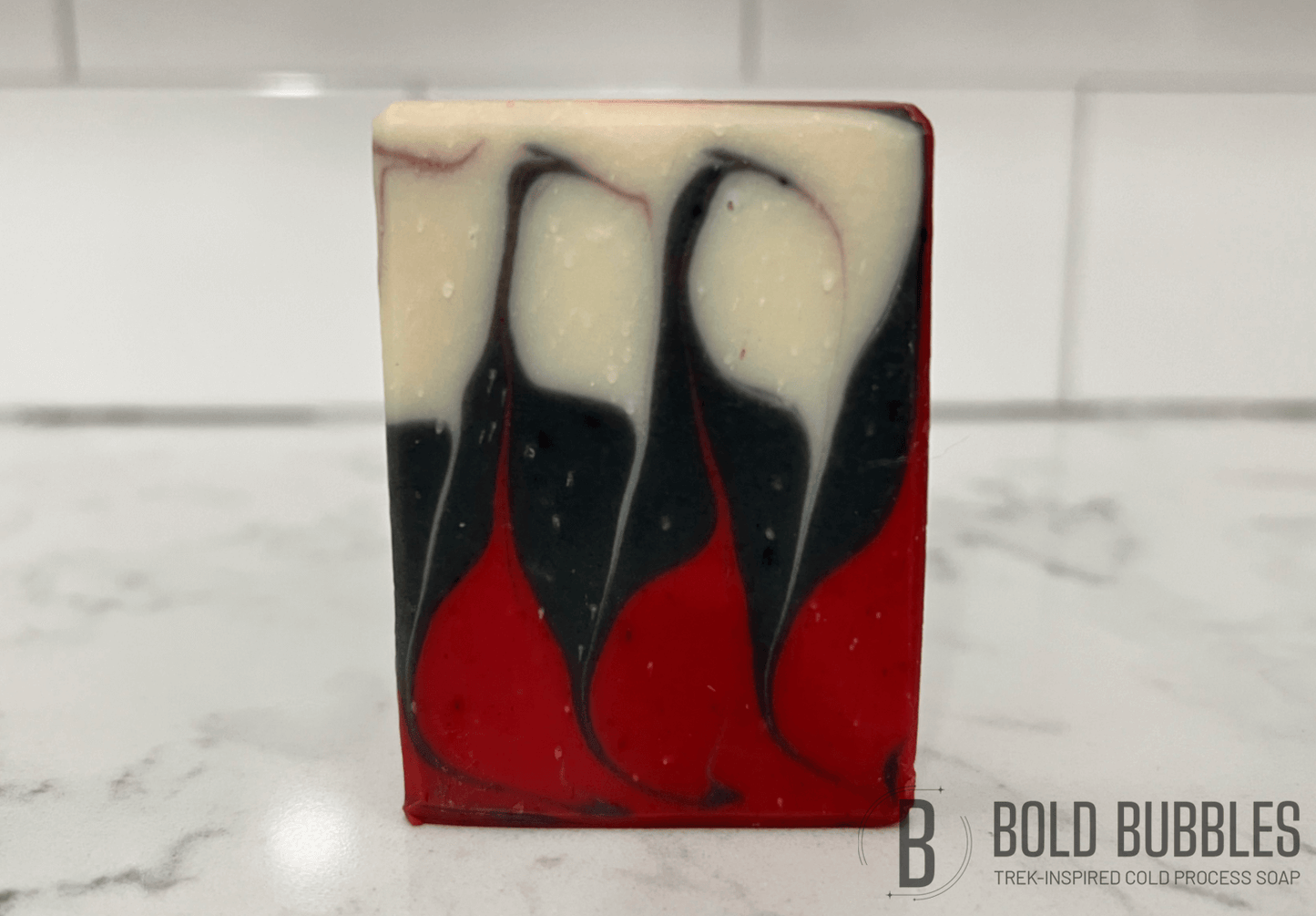 A red, black and white Taiwan swirl soap inspired by Q's courtroom in "Encounter at Farpoint." This one is  half the size (2.5 oz) of its full-size (5 oz) counterpart.