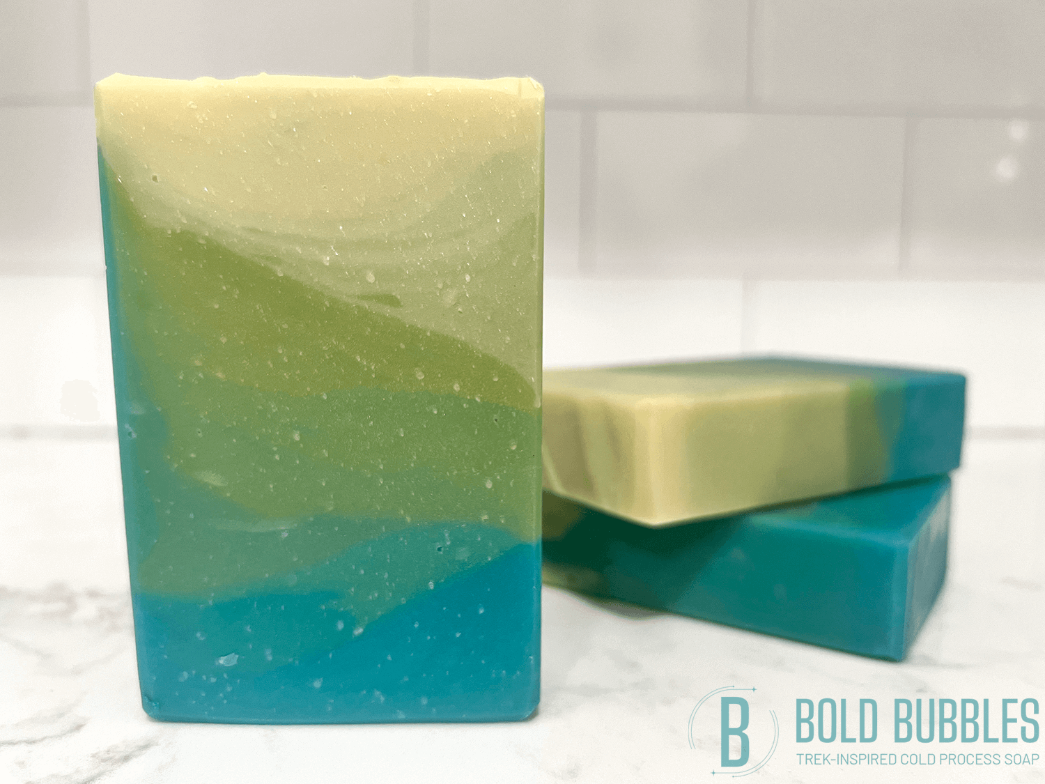 A bar of soap inspired by the relaxing beaches of Risa. The colors are a gradient of blue, to green, to sandy yellow. The scent is "sun and sand," a tropical breeze fragrance.