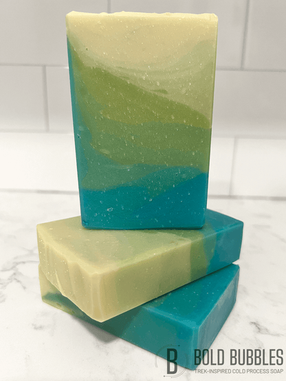 A bar of soap inspired by the relaxing beaches of Risa. The colors are a gradient of blue, to green, to sandy yellow. The scent is "sun and sand," a tropical breeze fragrance.