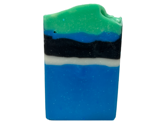 A bar of blue, white, and black soap designed in the Star Trek: Lower Decks-style uniform. At the top is a layer of green for D'Vana Tendi's hair. The scent is eucalyptus mint.