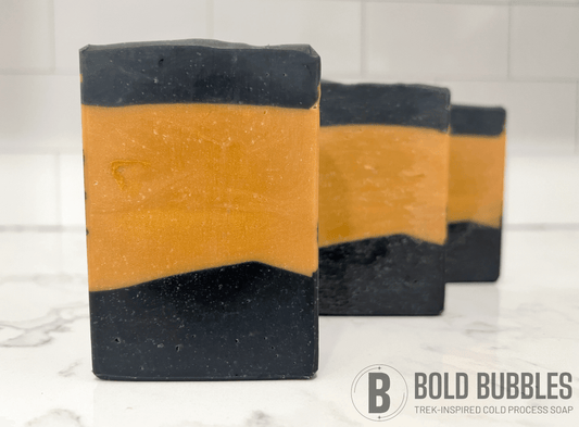 Gold and black bars of soap inspired by the design of the uniform Worf wore in Star Trek: The Next Generation. The bars are scented with lilac.
